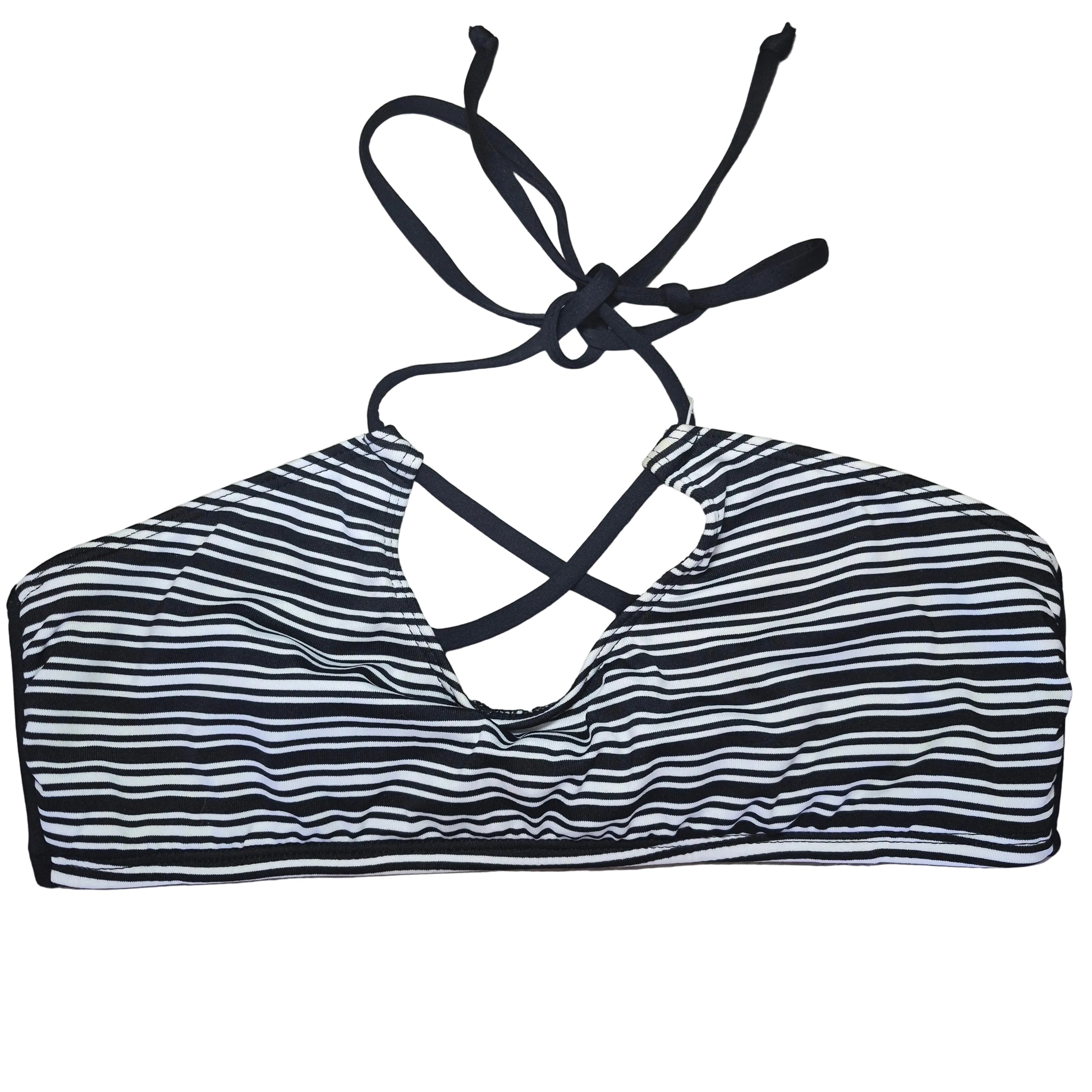 A black and white vertically striped bikini top with black tie straps, laid flat on a gray wood-look floor.